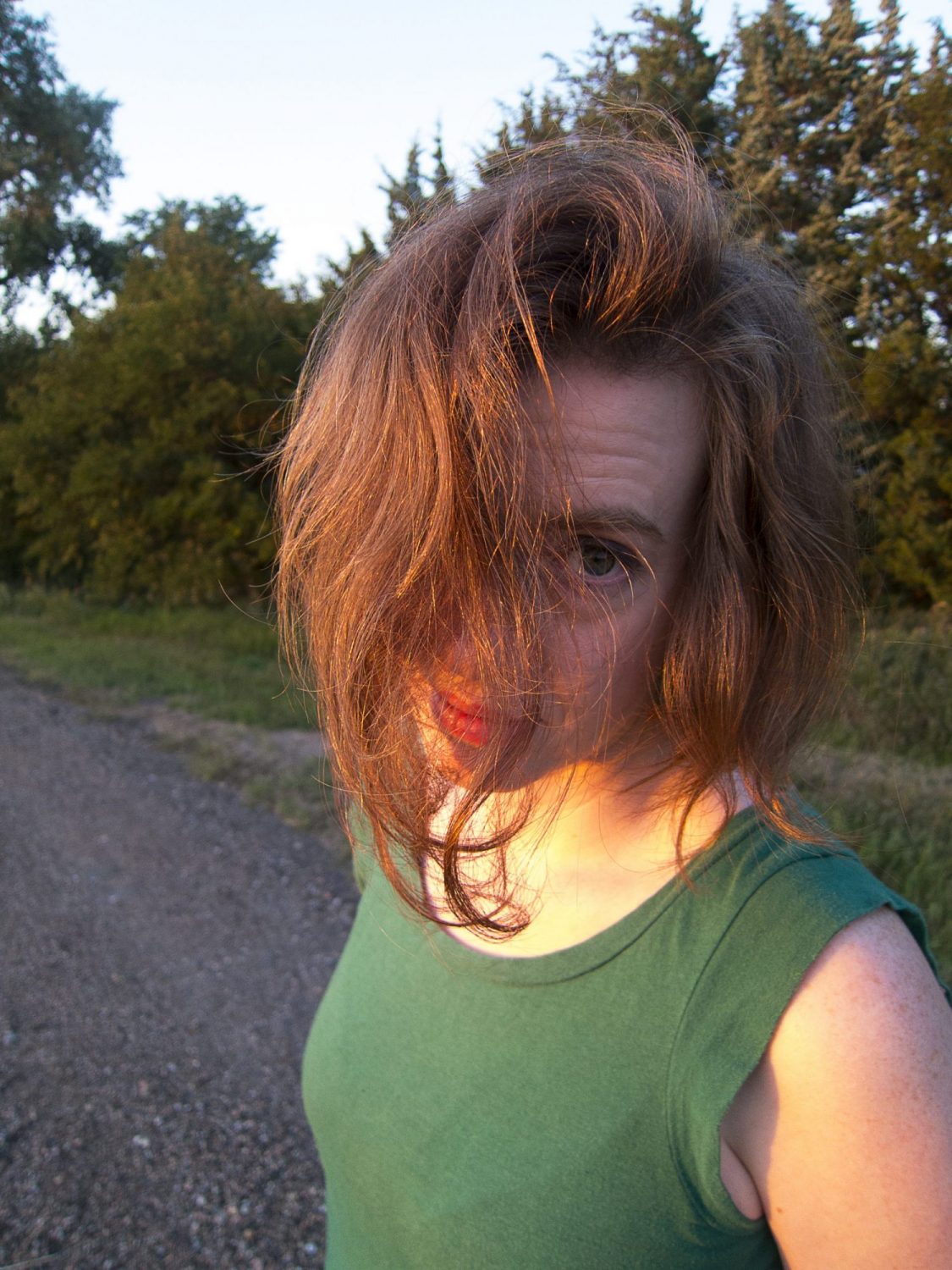 Mary on Gravel Road Putting Hair in Light to Make it Look More Red