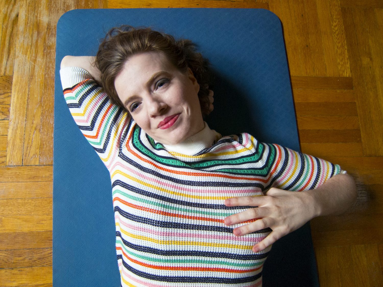 Mary on a Yoga Mat In a Striped Shirt Holding Chest and Head