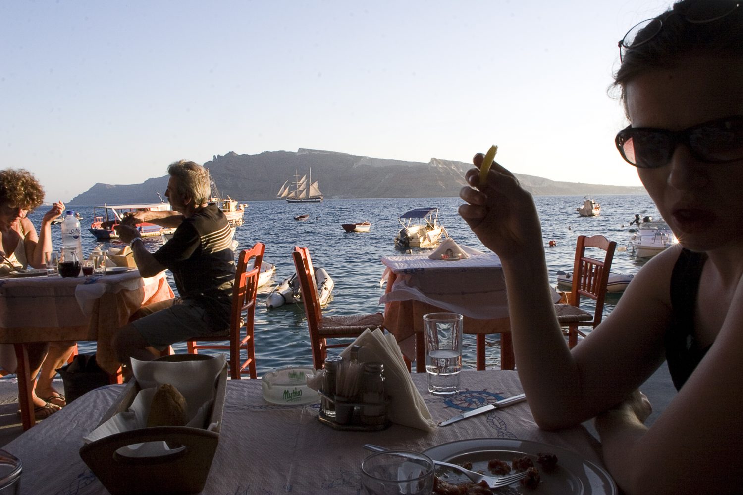 Woman Eating at Waterfront in Greece