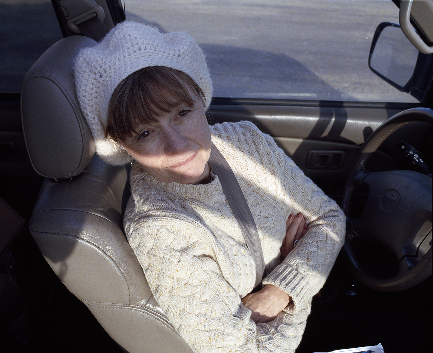Woman in a Car Looking Off White Hat and Sweater