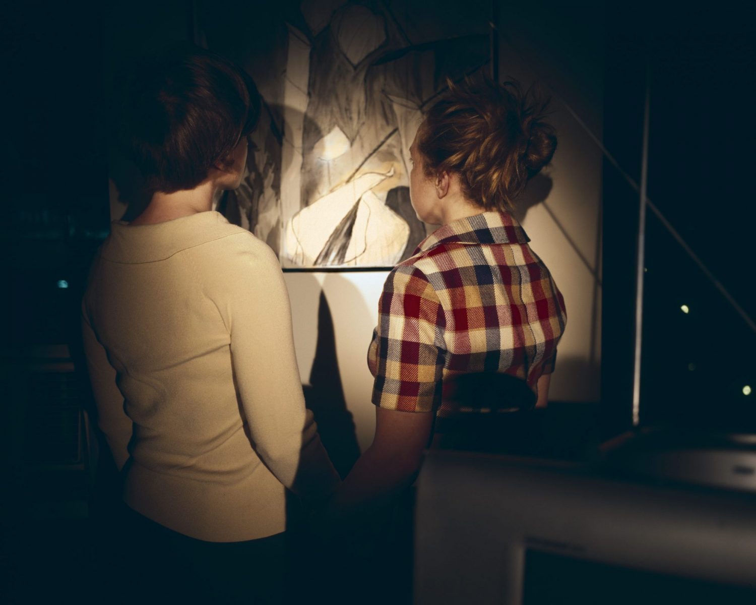 Two Women in Dark Looking At Painting